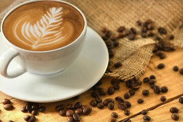 Closeup shot of a cappuccino surrounded by coffee beans