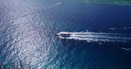 Aerial view of boat floating on sea under blue bright sky