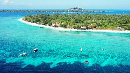 Obraz premium Aerial view of island surrounded by emerald water in Maldives