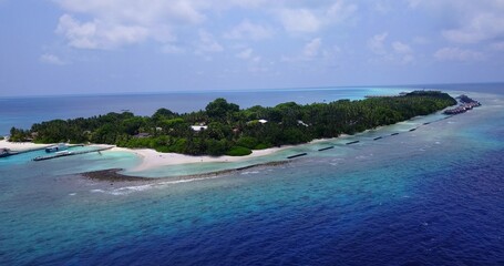 Fototapeta premium Aerial drone shot of a populated island in the Maldives washed by the Indian Ocean