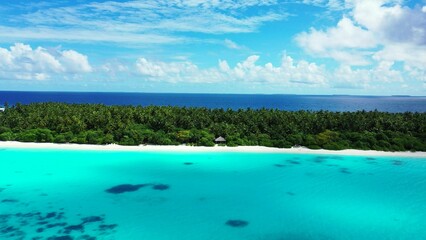 Fototapeta na wymiar Aerial drone shot of a paradise island in the Maldives washed by the waters of Indian Ocean