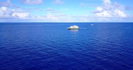 Aerial view of boats in the open sea under a cloudy sky