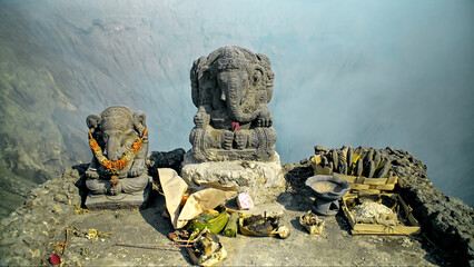 Ancient stone statue of Ganesha stands on a top of volcano Bromo