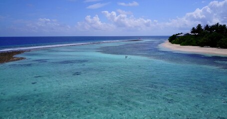 Aerial view of a white sandy beach and blue water in the Maldives
