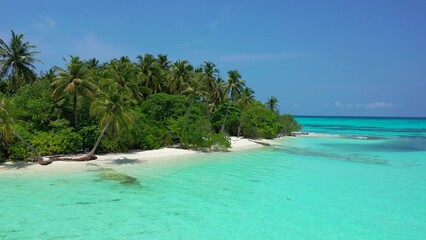 Scenic view of an island covered with greenery against a turquoise sea on a sunny day