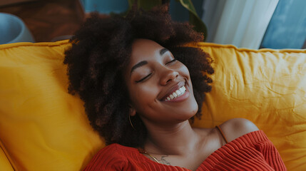 Happy afro american woman relaxing on the sofa at home Smiling girl enjoying day off lying on the couchHealthy life style, good vibes people and new home concept