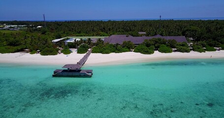 Aerial view of a resort in Maldives with a white sandy beach and tropical trees
