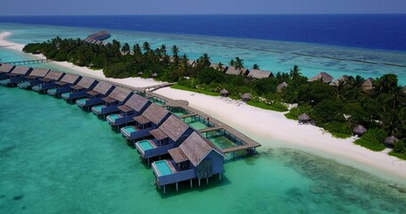 Aerial shot of Kuramathi water villas with white sandy beach in Maldives