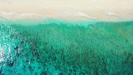 Aerial view of a turquoise sea with soft sands beach in an island of Maldives, Asia