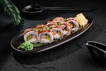 Delicious sushi roll platter on dark slate background