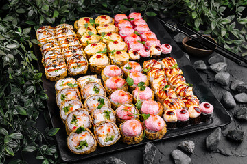 Assorted sushi platter on dark stone background