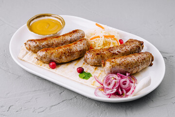 Grilled sausages with sauerkraut and mustard on plate