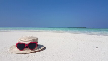 Beautiful view of a beach hat with glasses on the sand by the sea in Asia