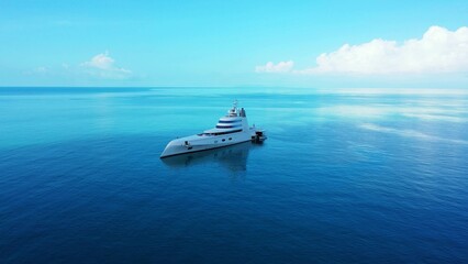 Beautiful shot of a yacht sailing across a deep blue ocean with the horizon in the distance