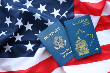 Fototapeta premium Passport of Canada with US Passport on United States of America folded flag close up