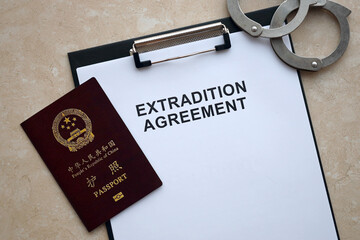 Passport of China Republic and Extradition Agreement with handcuffs on table close up