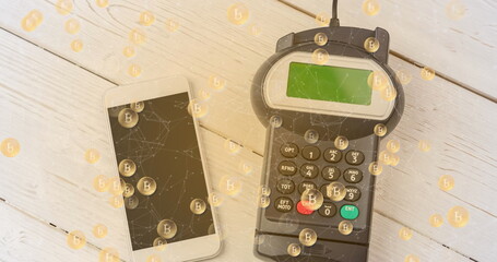 Image of bitcoins over smartphone and payment terminal