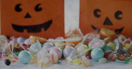 Grunge textured effect over halloween candies and scary pumpkin printed bags on white background