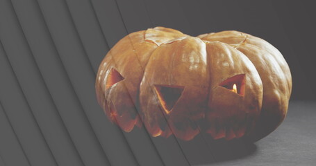 Image of lines over jack o lantern halloween pumpkin on grey background