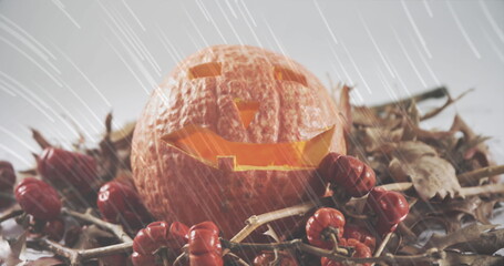 Naklejka premium White light trails falling over halloween carved scary pumpkin against white background