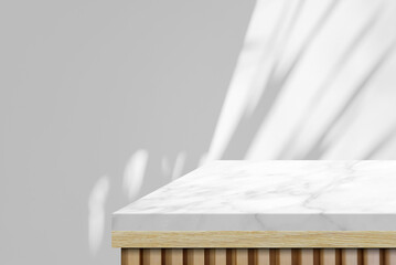 Wooden table with marble top table corner with light beam and leaves from window on wall background