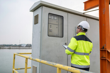 Electrical engineer man checking voltage at the Power Distribution Cabinet,preventive maintenance Yearly,Supervisor Working at a wastewater treatment plant