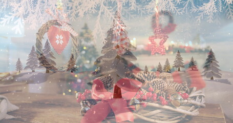 The image shows snow falling over a winter landscape, with fir trees and a grapevine wreath with red - obrazy, fototapety, plakaty