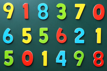 Colorful numbers on green background, flat lay