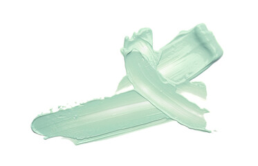 Strokes of green color correcting concealer on white background, top view