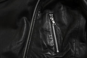 Texture of black leather jacket with zipper as background, top view