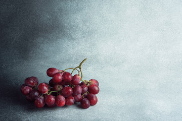 Vibrant Red Grape Bunch on Textured Grey Surface with Space for Text
