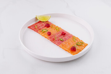 Fresh salmon sashimi plate with lime and herbs