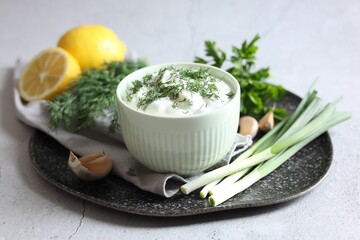 Delicious yogurt in bowl and ingredients on light textured table