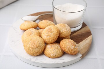 Tasty sweet sugar cookies and milk on white tiled table, closeup