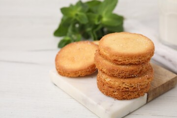 Tasty sweet sugar cookies and mint on white wooden table, closeup. Space for text