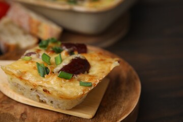 Spatula with piece of tasty sausage casserole on table, closeup. Space for text
