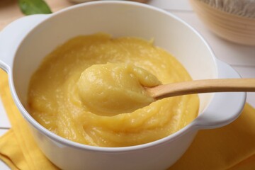 Taking delicious lemon curd from bowl at table, closeup