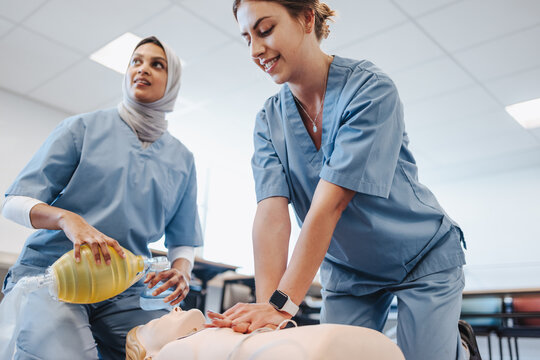 Female student doctors perform CPR on a medical simulator in a teaching hospital