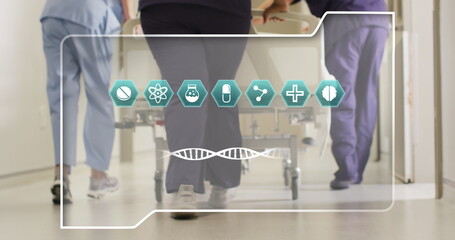 Image of dna strand and icons over diverse doctors at hospital