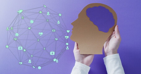 Image of globe of connections with icons over hands holding human head on purple background