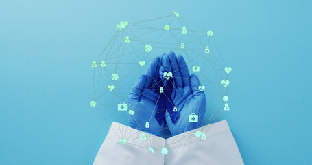 Image of network of connections with icons over hands holding blue ribbon on blue background
