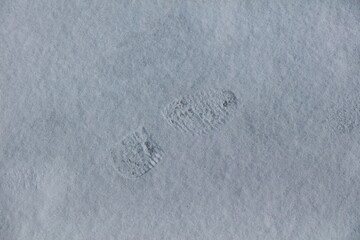 Closeup of boot footprint in snow in spring.