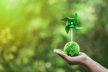 ESG and clean energy paper windmill concept on green background. Sustainable resources. Earth Day. Investing in green businesses. Reducing carbon and creating clean and sustainable energy.	
