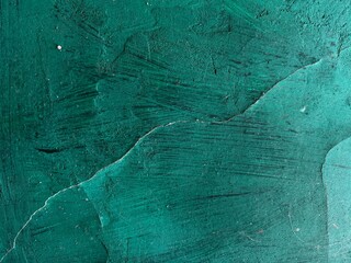 Close-up of a green concrete wall with scuffs. The background texture is green.