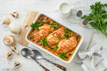 Baked chicken breast bbq with mushrooms and garlic in cream sauce on white wooden table backgrounds. Top view image with ingredients for cooking. Top view with copy space.