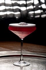 Cocktail in a martini glass on a dark background.