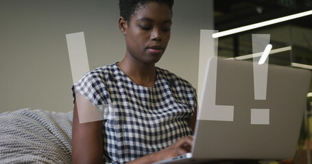 Image of lol text over african american businesswoman using laptop