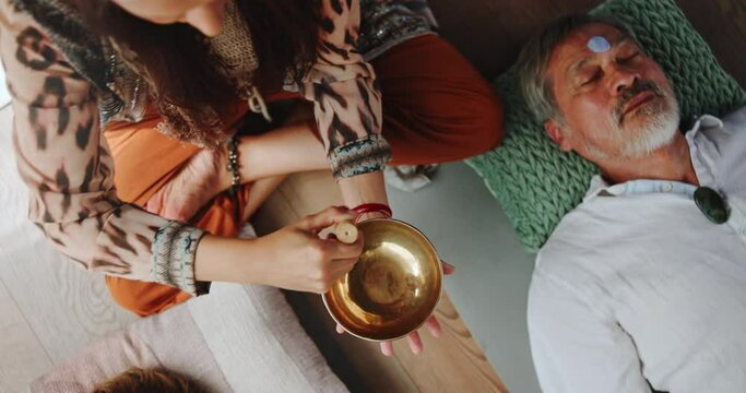 Person, hands and sound therapy with bowl above in peace, audio wave or vibration together. Top view or closeup of buddhist creating music for healing, culture or stress relief in treatment or mantra