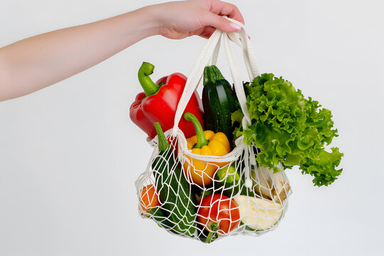 Juicy vegetables in a string bag on a white background. Healthy nutrition concept