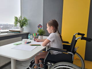 Young Girl Sitting in Wheelchair at Desk